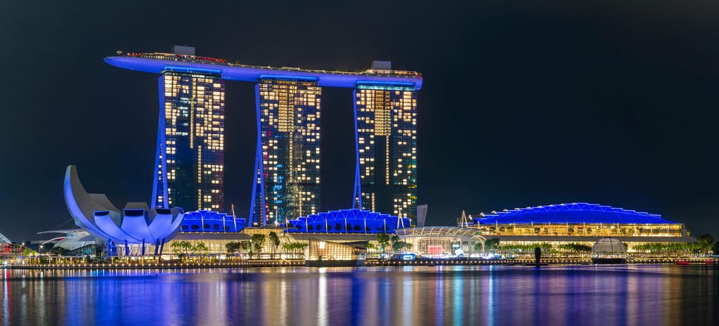 A vibrant nightscape of Marina Bay Sands beautifully reflecting on the waterfront in Singapore.