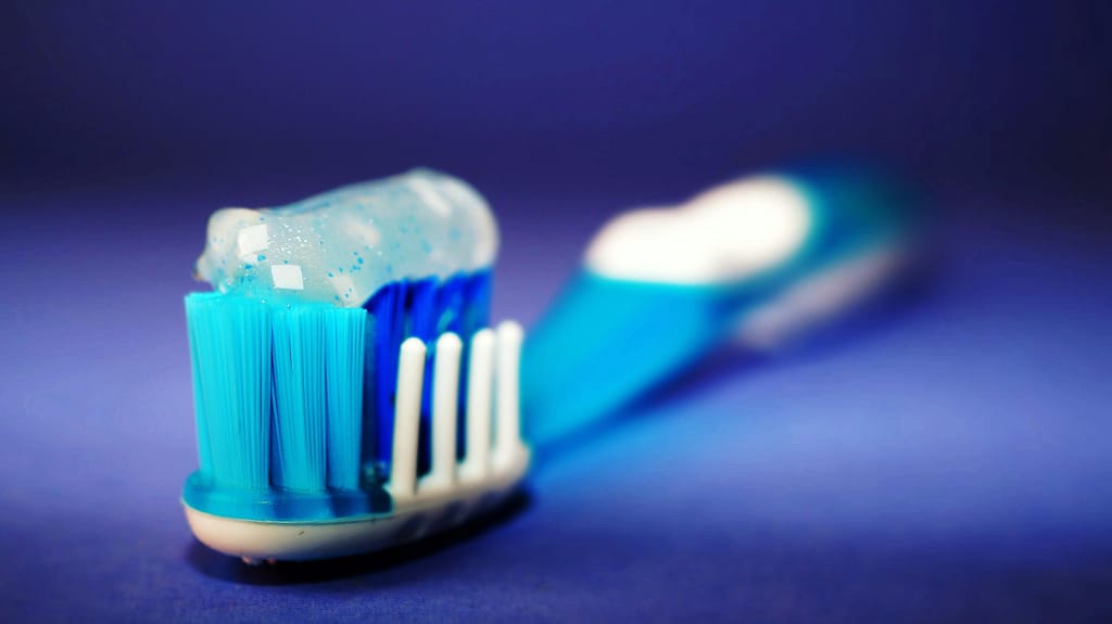 pexels-photo-298611-298611 Macro shot of a toothbrush with blue toothpaste and blurred background.