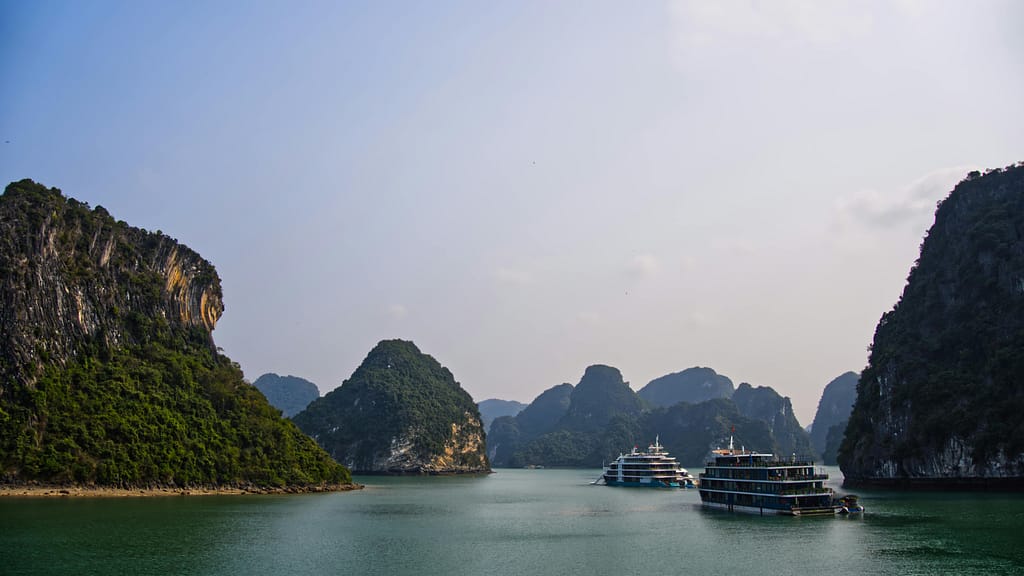 Breathtaking view of cruise ships navigating through the limestone islands of Halong Bay, Vietnam.