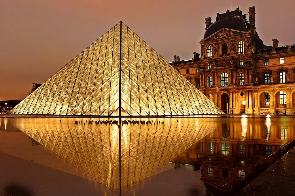 france-landmark-lights-night-2363 Stunning nighttime view of the illuminated Louvre Pyramid and reflection in Paris, France.