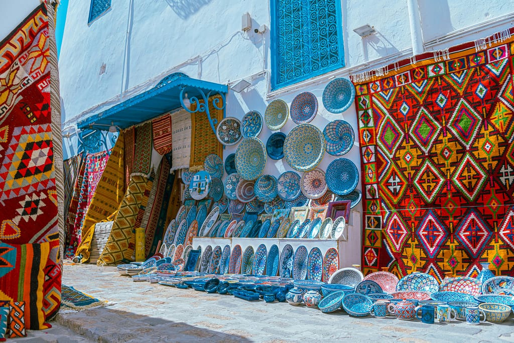 Vibrant Tunisian bazaar displaying traditional pottery and carpets in Carthage.
