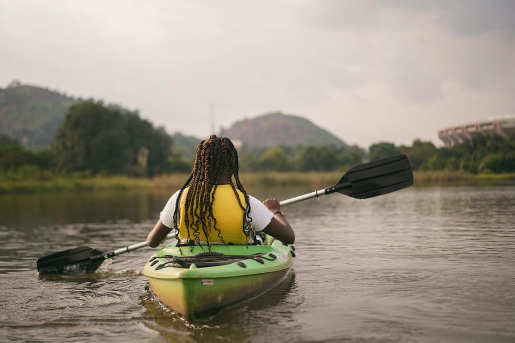 Experience kayaking on calm waters in Abuja, Nigeria, with picturesque views of lush landscapes.