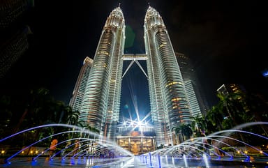 pexels-photo-462671-462671 Stunning night view of the illuminated Petronas Twin Towers in Kuala Lumpur with fountains in the foreground.