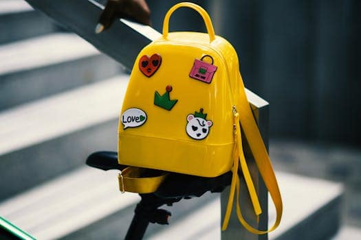 pexels-photo-934673-934673 Stylish yellow backpack with playful stickers on a bicycle saddle outdoors.