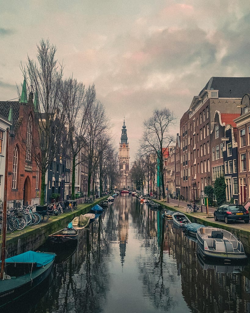 pexels-photo-30740785-30740785 Stunning canal view in Amsterdam featuring historic Zuiderkerk and traditional architecture.
