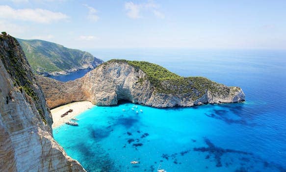 Stunning aerial view of Navagio Beach in Zakynthos, Greece, featuring turquoise water and a sunken ship.